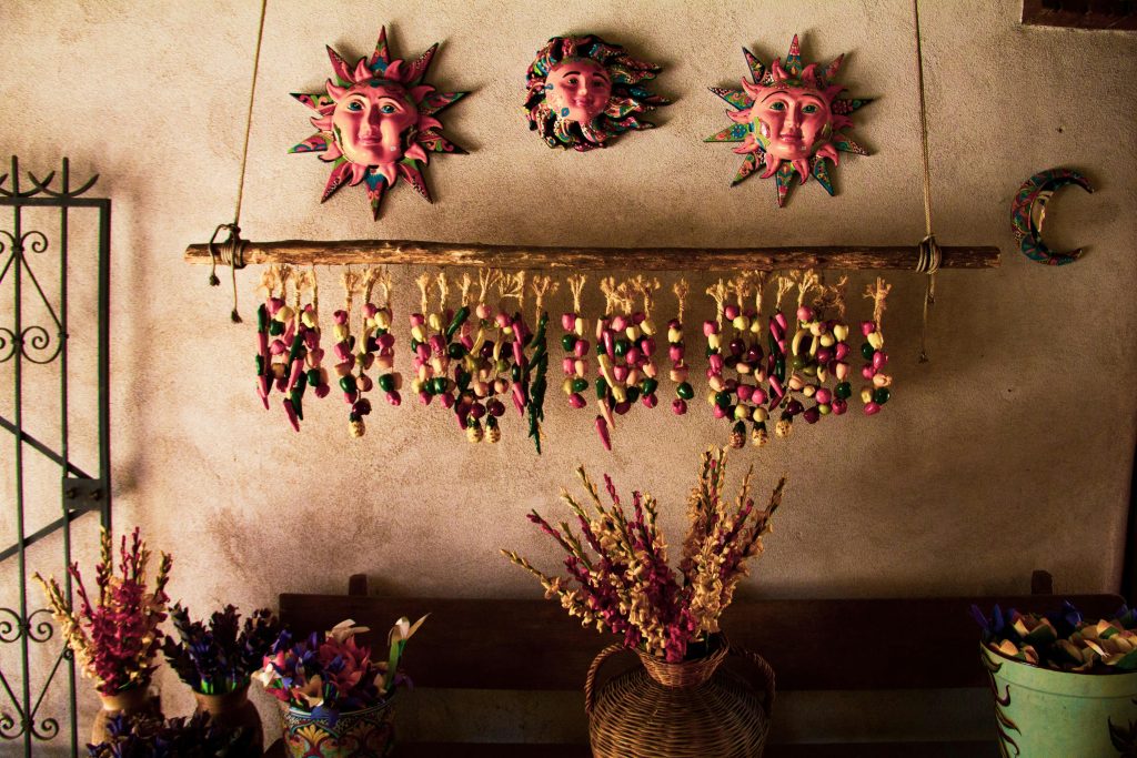 Dries botanicals and terra cotta artwork on a adobe wall