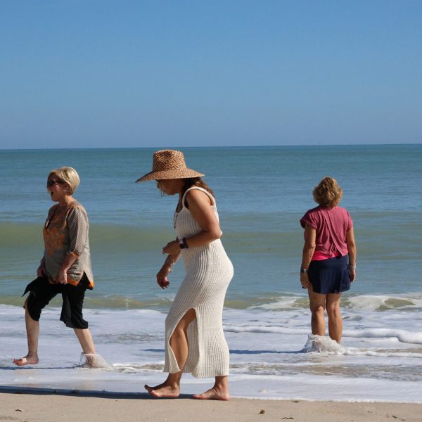 Group of women explore the beach with bright blue water