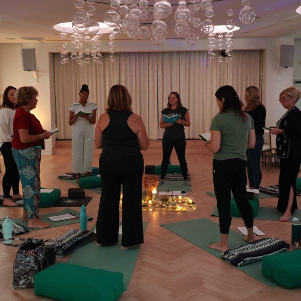 Group of women stand in a circle in a resort ballroom having a conversation